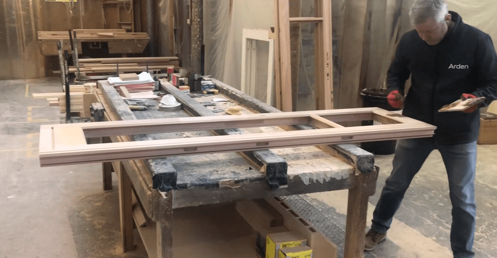 man sanding timber windows